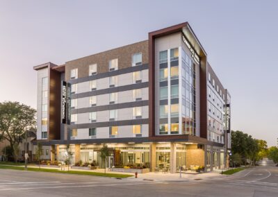 Front exterior of new hotel at dusk with lights on