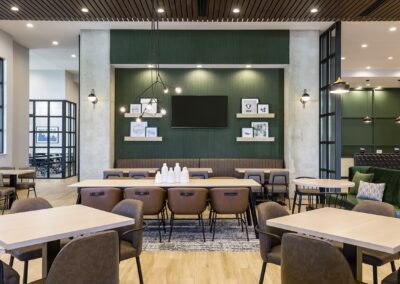 Dining area of hotel lobby with front desk and meeting room in background